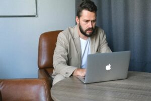 Professional executive researching LinkedIn profile on laptop